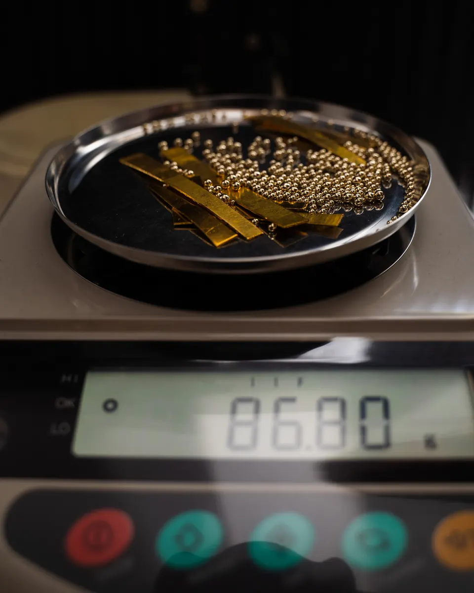 Goldgranulat und Goldstreifen auf einer Digitalwaage